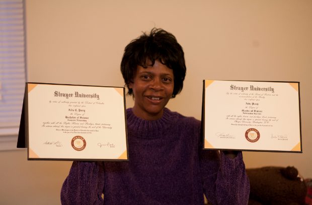 Aida Perry holds up her diplomas.