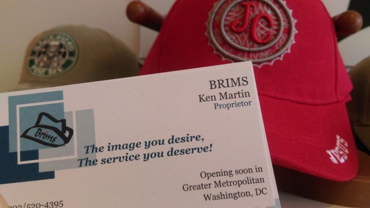 A photo of a business card and a ball cap