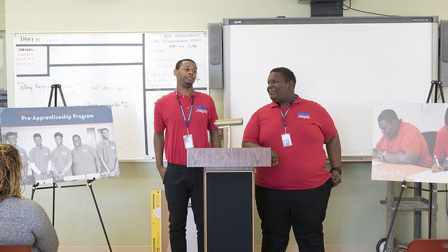 Dunbar High School graduates Daniel Gibson and Quanya Reese speak to classmates about being hired by DCRA after completing a pre-apprenticeship program