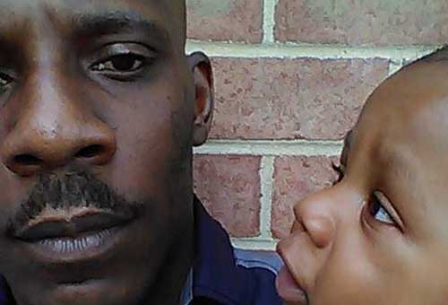 A photo of Ron Dudley holding his son.