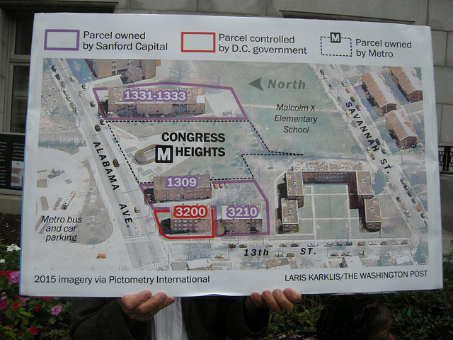 A demonstrator displays a blown up map at the Sept. 6 event. The graphic originally ran in a 2015 Washington Post article about living conditions and gentrification fears in these buildings surrounding the Congress Heights Metro.