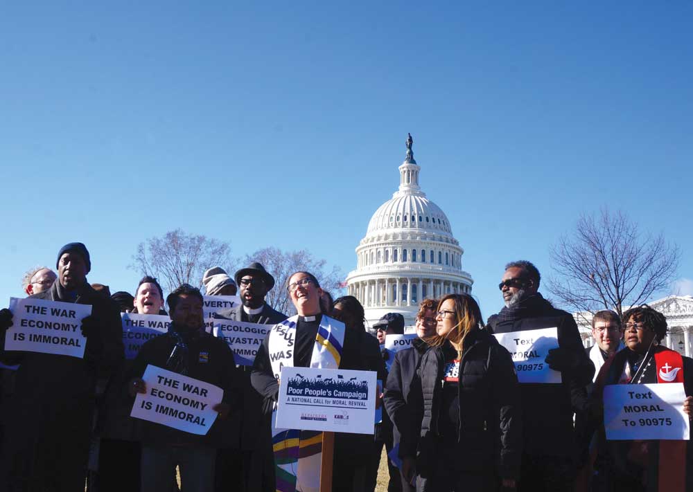 Photo of activists, holding signs, in front of the U.S. Capitol.