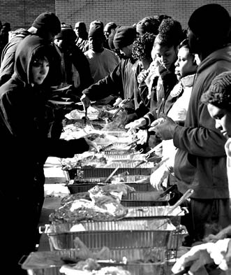 Volunteers serve food at We Feed Our People outside of the MLK Lirbary.