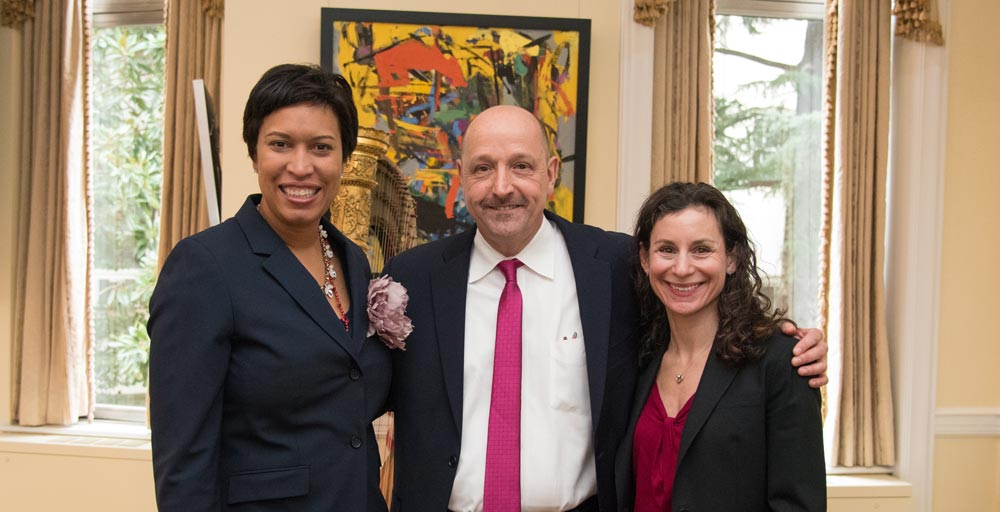 Photo of Mayor Muriel Bowser, Friendship Place President and CEO Jean Michel Giraud and D.C. Department of Human Services Director Laura Zeilinger standing together, smiling.