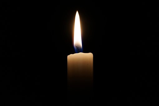 A candle against a black background