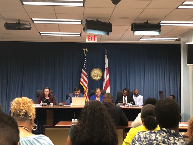 A panel of DC Council members interviews public housing executives at the July 12 meeting.