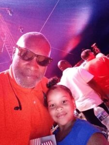Photo of a man and a little girl in a crowd.