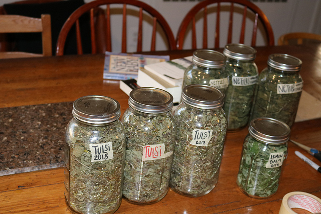 A photo of jars of herbs on a table.
