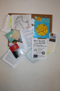 A photo of a bulletin board covered in illustrations and flyers.
