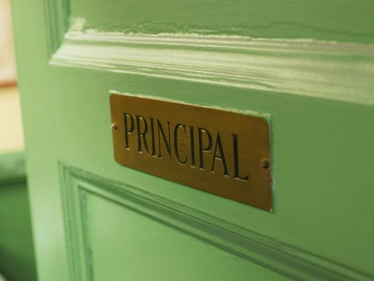 A photo of a green door with a sign reading "principal"
