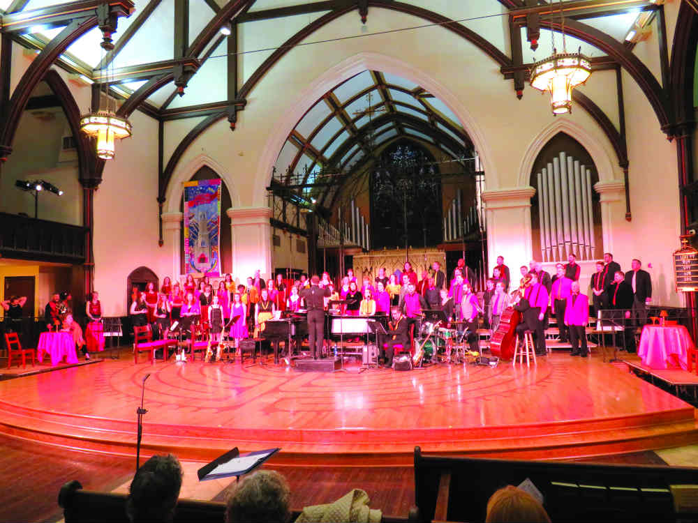 COlor photo of a stage with a large band bathed in purple lights from over head