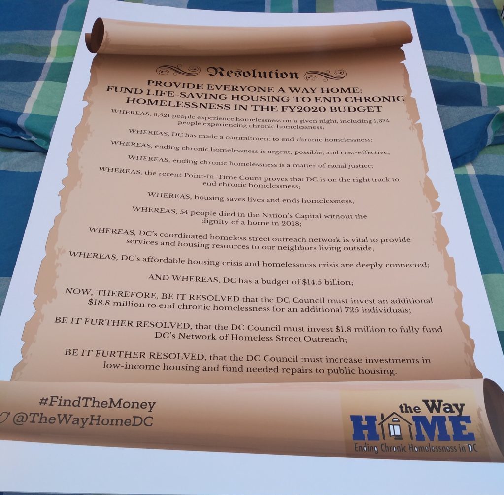 Photo of a blown-up copy of the Way Home Campaign resolution printed to look like a parchment scroll.