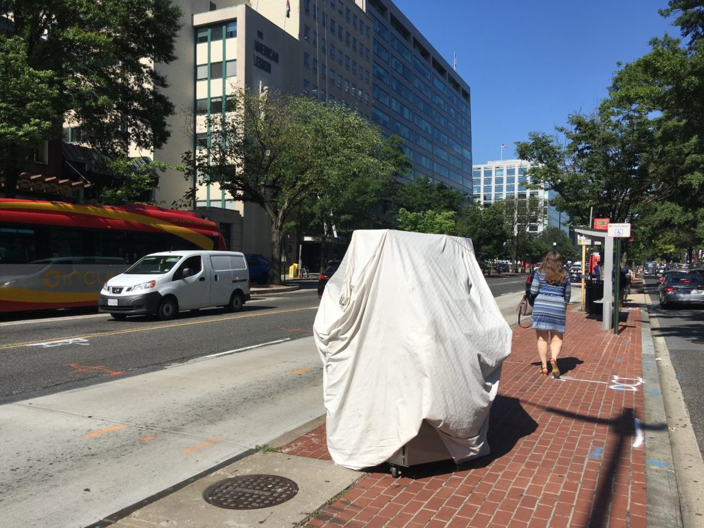 A photo of a metal cart covered with a white sheet.