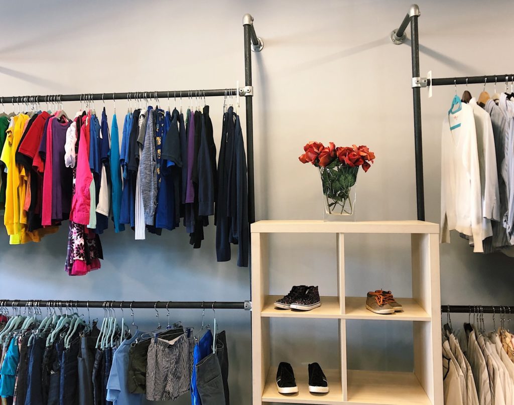 Photo of clothes and shoes for sale in a bright and clean merchandising display at Martha's Outfitters
