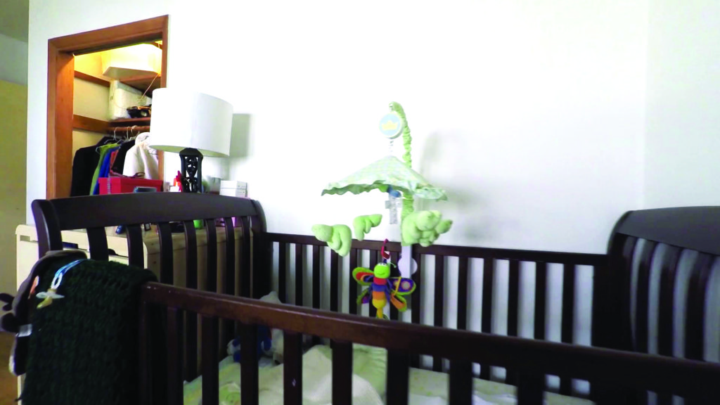 Photo of a crib with a mobile.