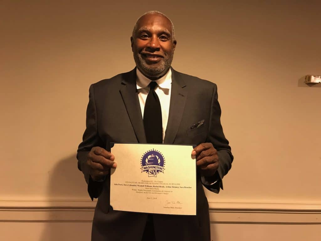Photo of Wendell Williams grinning and holding his award certificate.