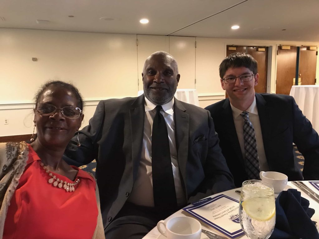 Aida Peery, Wendell Williams, and Jeff Gray seated at a banquet table while smiling.