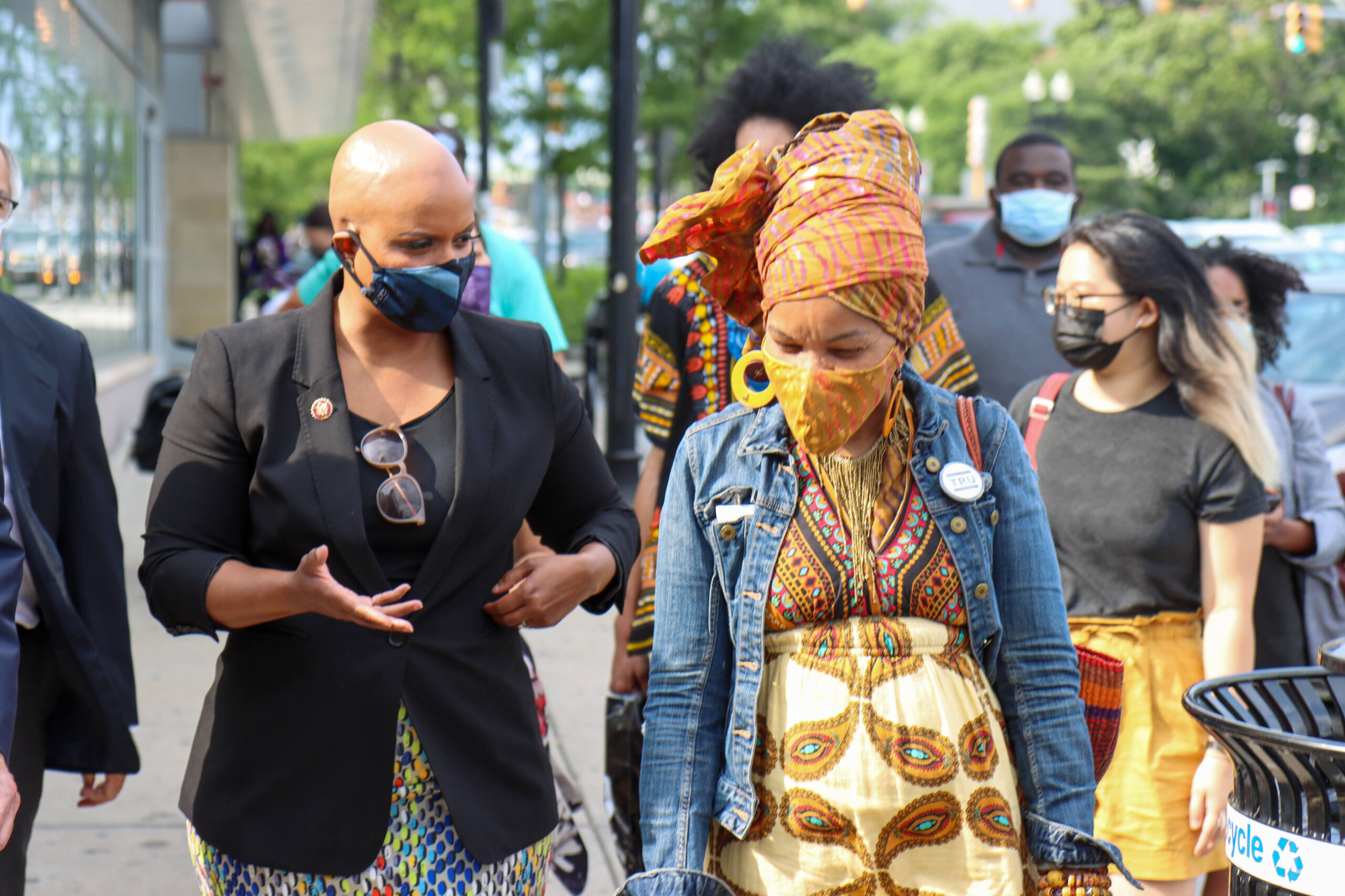 Photo showing Rep. Pressley walking next to a woman in a crowd. Both are wearing masks to prevent against the spread of COVID-19.