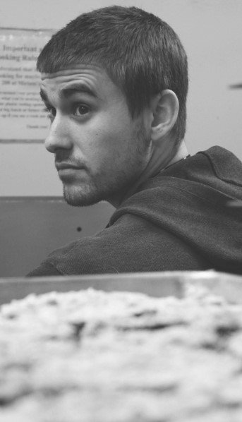 Image of John Murphy overseeing volunteers cooking in the kitchen.