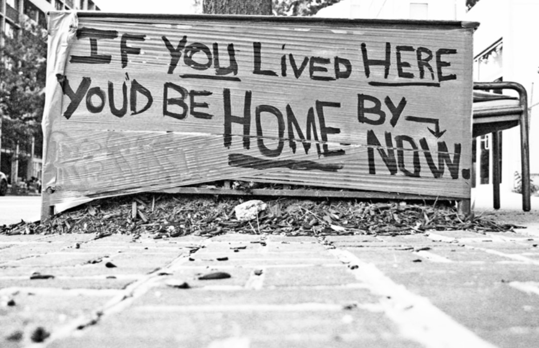 Photo of a protest sign that says "If you Lived Here You'd Be Home By Now"