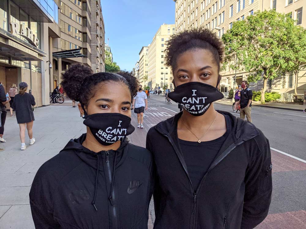 Photo showing two teenage girls wearing face masks that say "I can't Breath, Black Lives Matter."