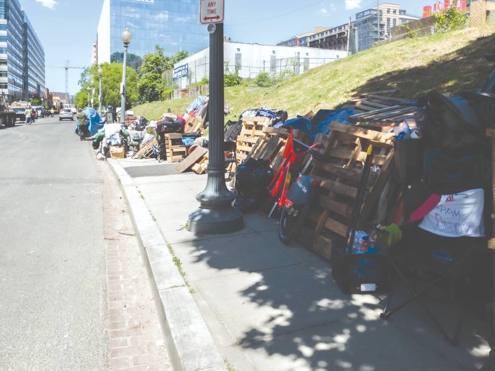 Belongings to displaced residents of the encampment line the street outside the cleaning zone