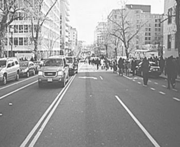 People walk down mostly closed streets towards the National Mall