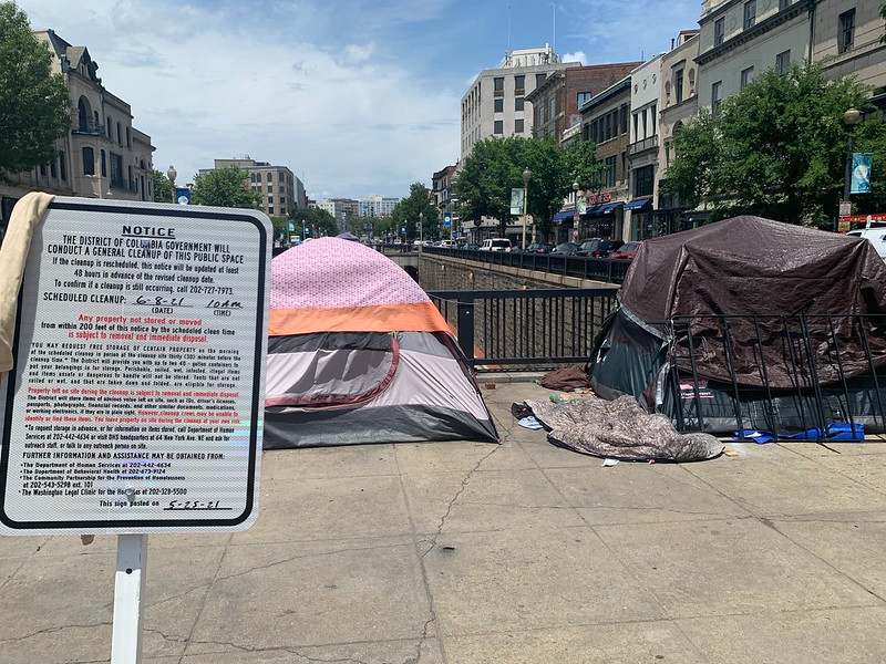 The notice is on the left of the photo; two tents are in the picture.