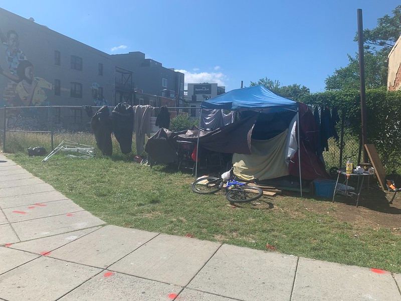 A tent and belongings more than 200 feet from the notice sign