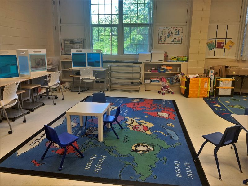 The playroom has a world map rug and several activity centers