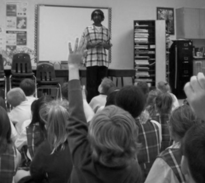 A young child raises a rand to ask Raymond Allen a question
