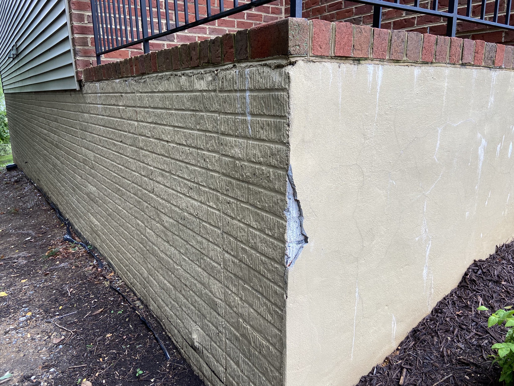 A corner of the foundation of a building with a missing piece. 