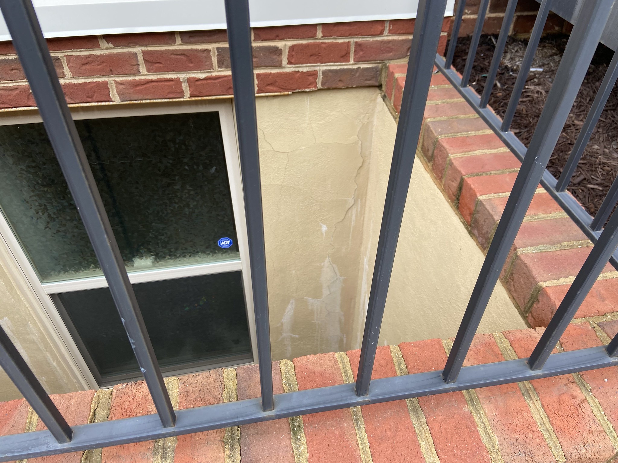 Spiderweb cracks on the building foundation.