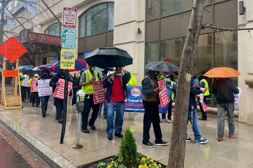 A photo of a group of protestors holding umbrellas