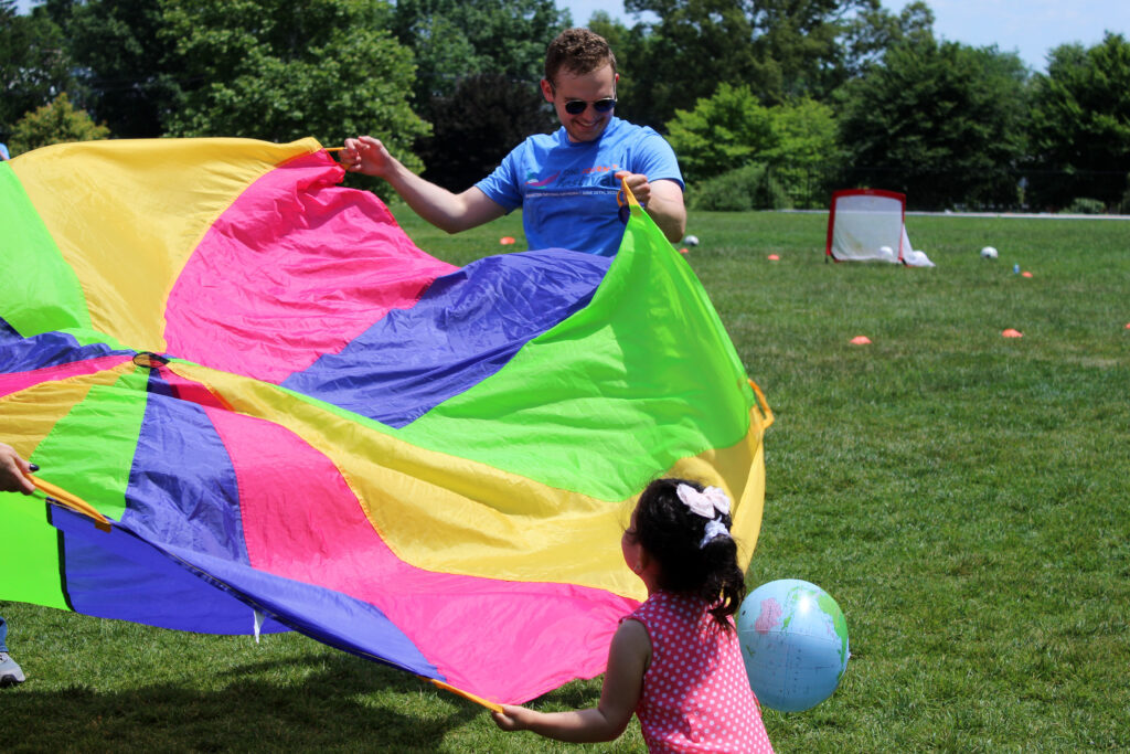 A festival volunteer plays with a child.