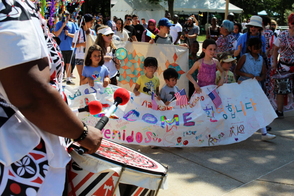 Batalá Washington plays as the children walk with their 'Welcome' banner.
