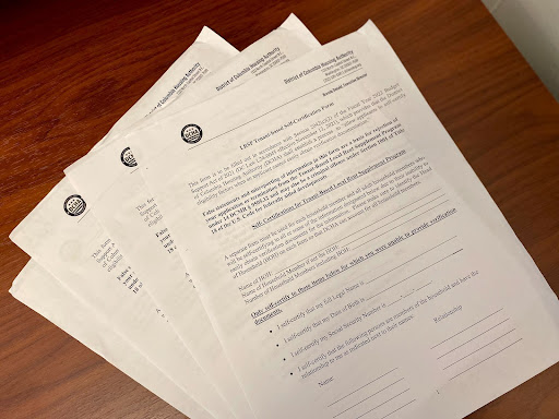 Four self-certification forms on a brown desk.
