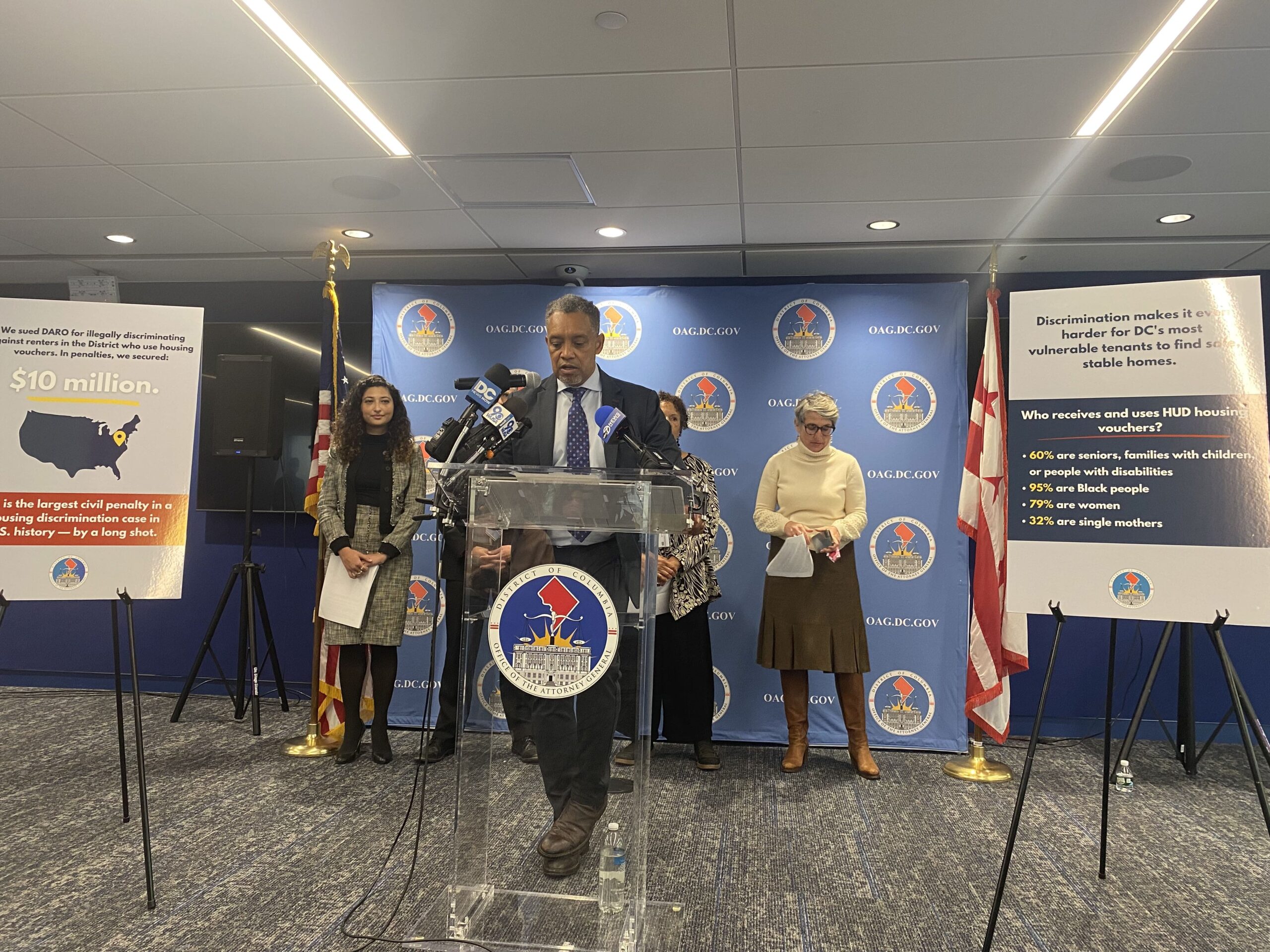 Karl Racine stands behind a podium.
